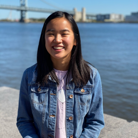 NHC PGH member Lily smiling on a sunny day with a bridge in the background