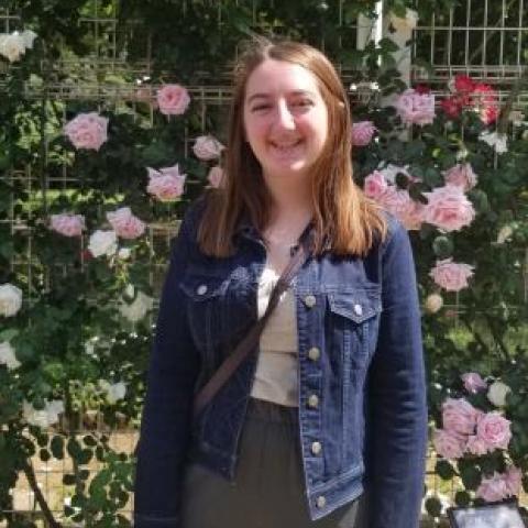 NHC PGH member Maria smiling and posing with a scenic background outdoors