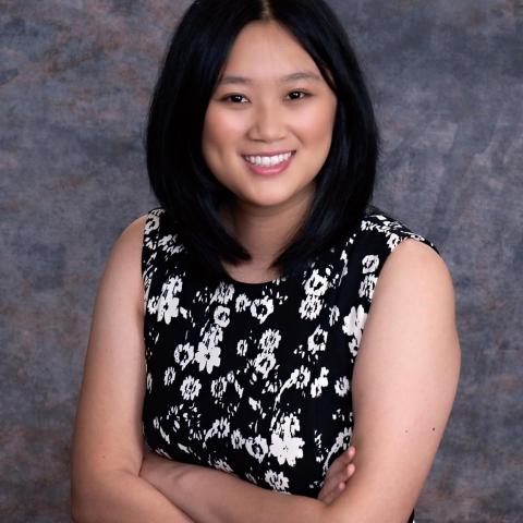 NHC member Amanda Meng is wearing a black and white flowered top, smiling and arms folded.