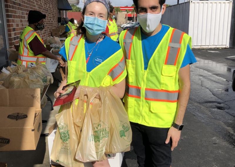 Performing outside service at a drive-through food giveaway event with another AmeriCorps Member. 