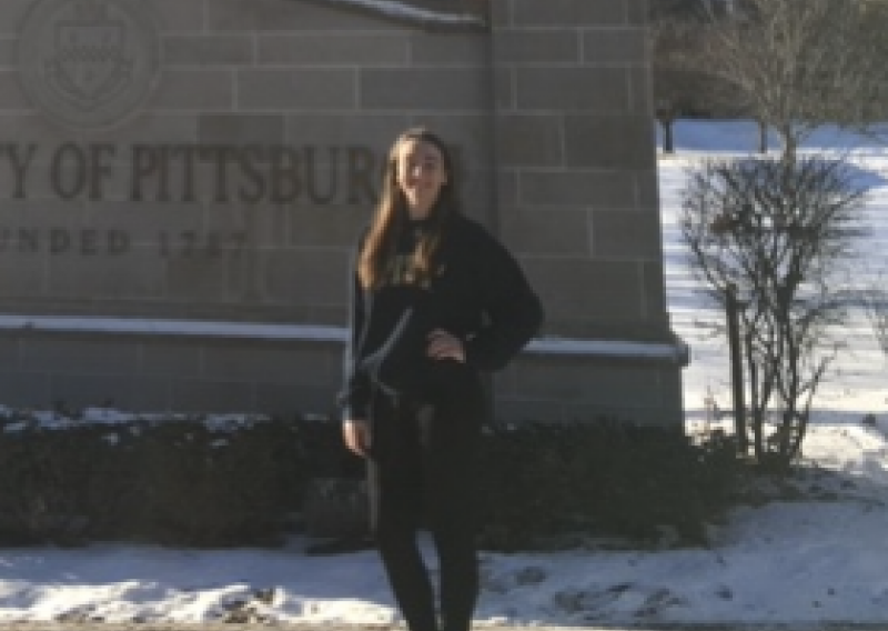 NHC PGH member Mary Margaret standing in front of a University of Pittsburgh sign