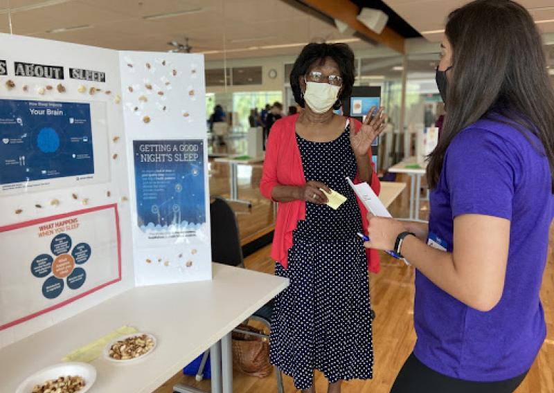 Carly listening to one of the senior’s science fair  presentations on the connection between sleep and brain health.