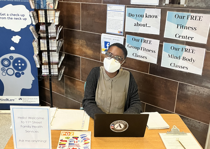 Jessica sitting at a  table advertising free wellness classes