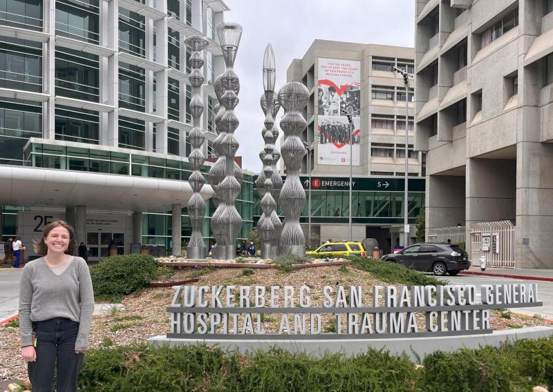 Morgan is standing next to a sign that reads Zuckerberg San Francisco General Hospital and Trauma Center.