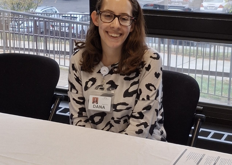 Dana Scandura is sitting at an information table at a health fair.