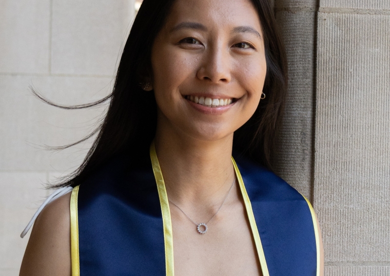 Kaylee smiling with blue graduation collar on