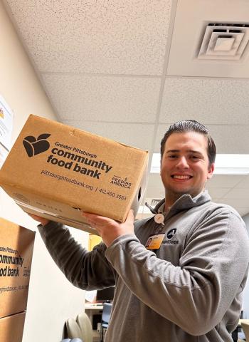 James is holding a food box.