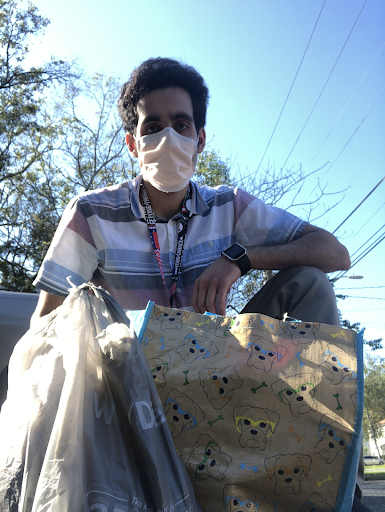 Armaan with a Thanksgiving basket and turkey that he is about to deliver to a client.